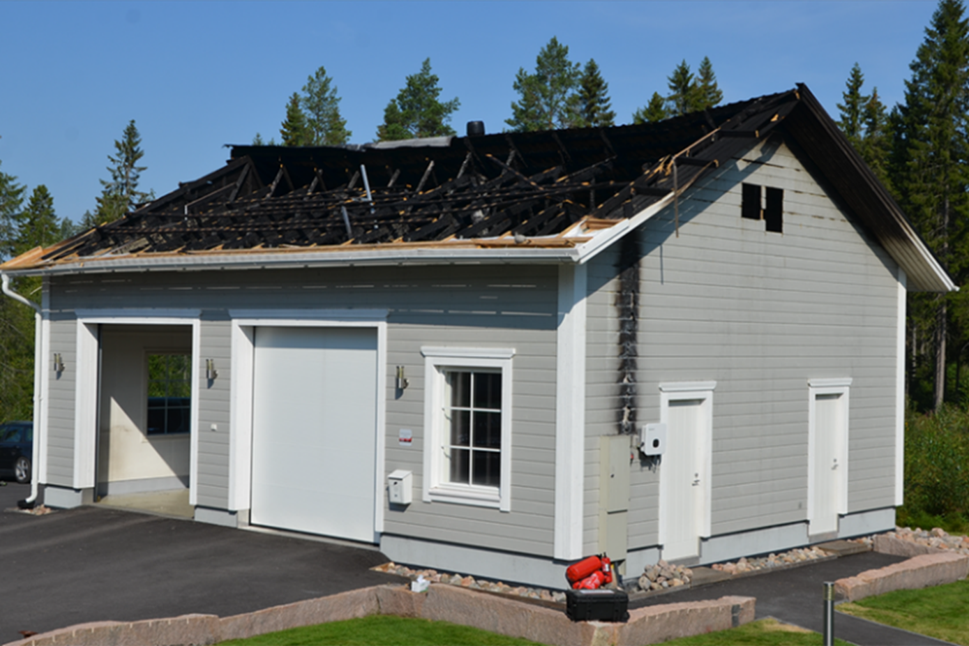 Autovarasto, jonka katto on palanut. 