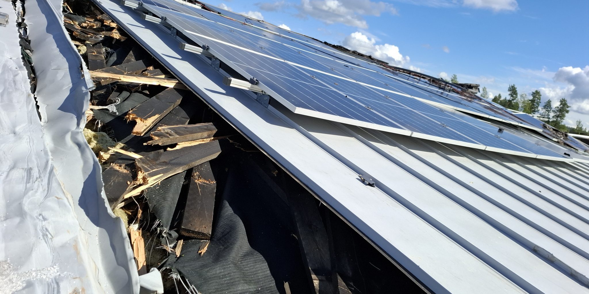 Kuva talon katolta, jossa aurinkosähköjärjestelmän reunassa on palanutta kattomateriaalia.